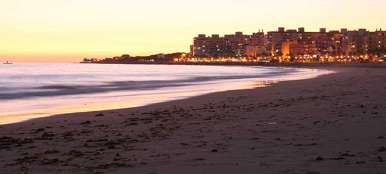 La Playa de la Costilla con la puesta de sol y las luces del paseo marítimo y los chiringuitos a pie de playa, Rota (c) José Manuel Bolaños